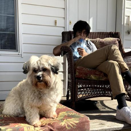 Faaiq Waqar sitting on a porch with a dog